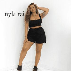 nyla rei, independent womenswear brand, british womenswear brand, black owned womenswear brand, mixed race young woman with black jog shorts and crop top tattoo on arm,