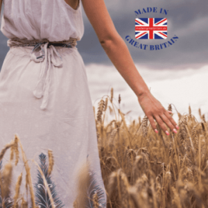british made women's clothes, woman walking through british field of corn with cloudy sky
